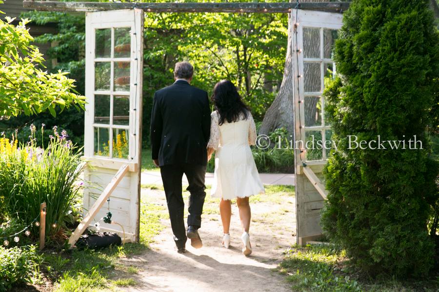 Couple Walking Under Wedding Arch